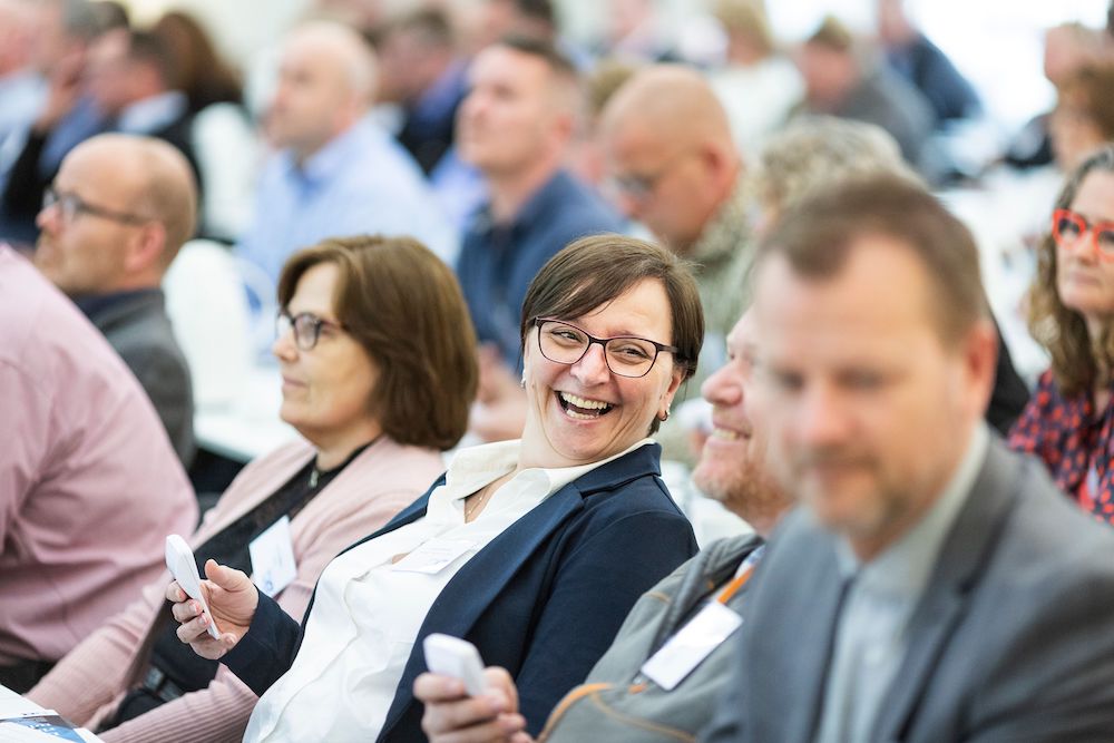 Middle aged woman laughing with her colleague during a conference