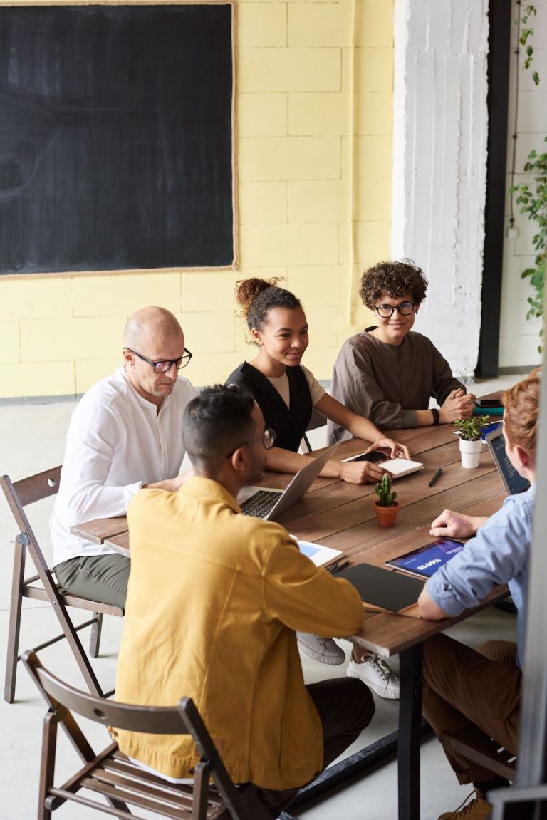 Ethnically diverse group of people sitting at table